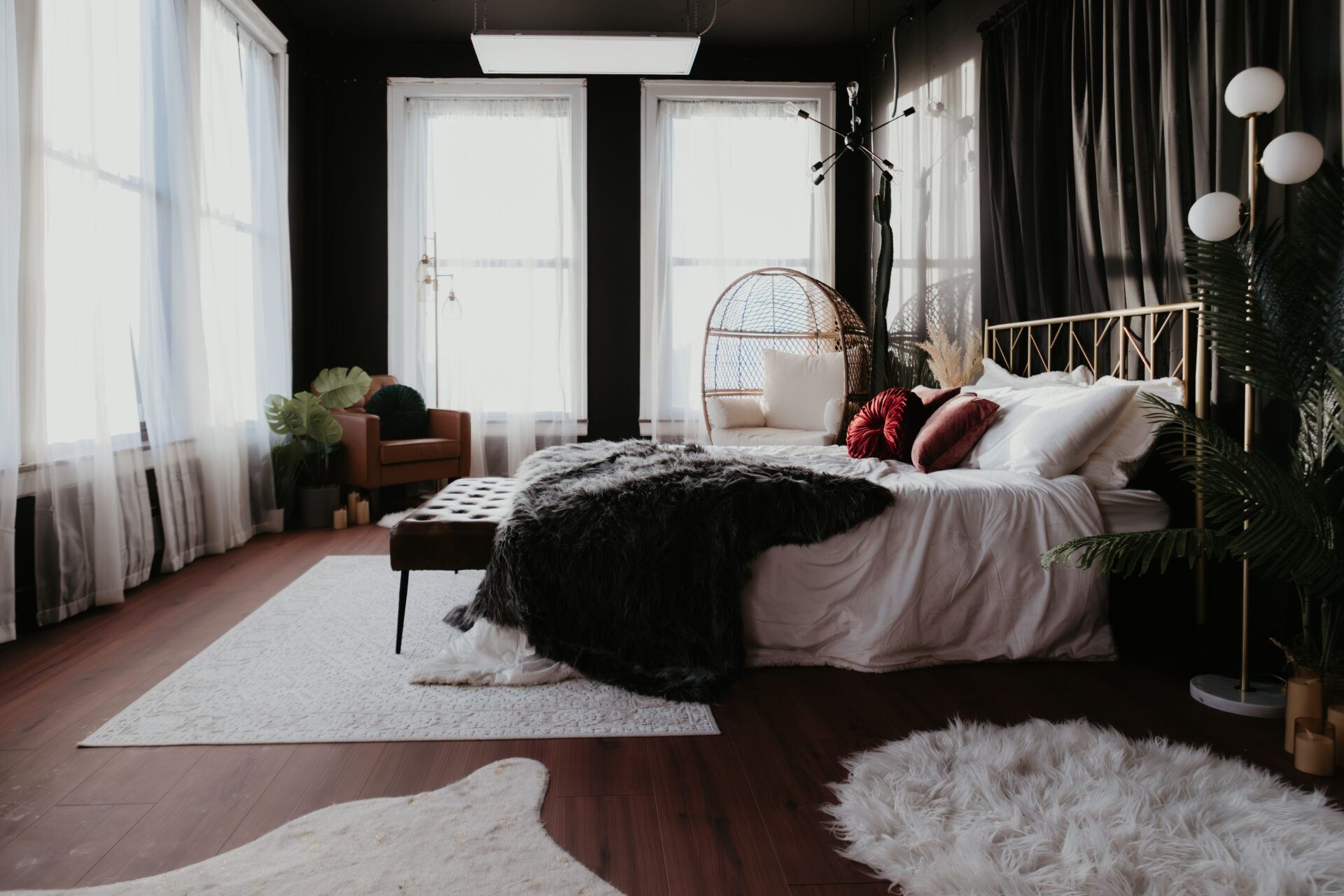 Modern boho boudoir studio in Bay City, Michigan featuring a gold bed frame, cozy textures, natural light, and editorial-style décor.