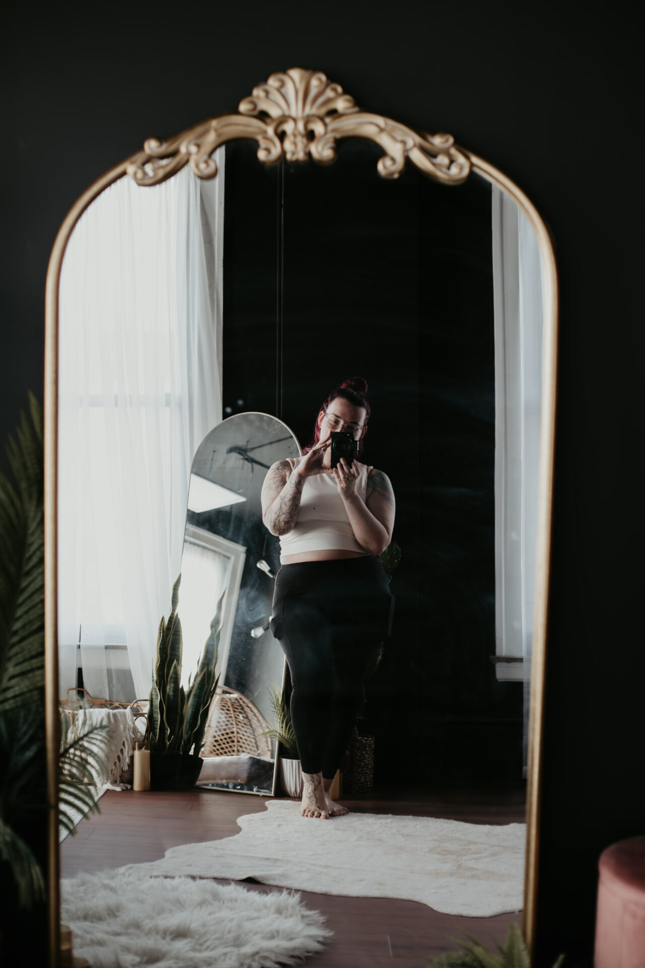 Photographer taking self-portrait in ornate gold mirror at Arielle Roth Boudoir studio in Bay City, Michigan