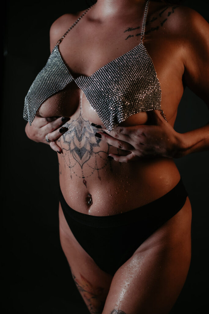 Boudoir photography Bay City Michigan – woman in rhinestone top and black lingerie with glitter skin